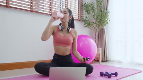 Woman Drinking Water After Workout at Home
