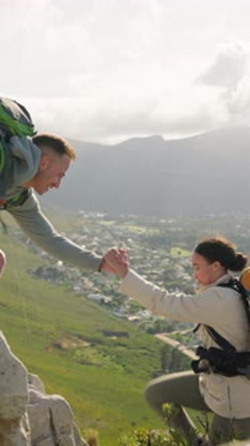 Man Helps Woman Climb Rocky Mountain Summit