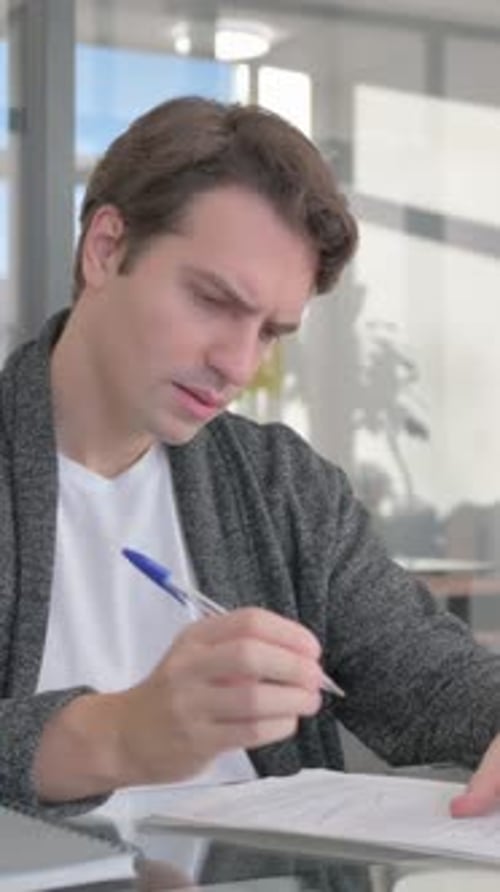 Young Man Working on Documents in Office, vertical video