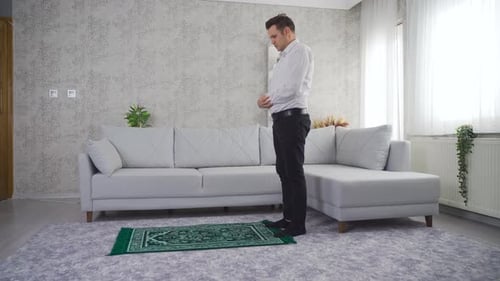 Man in Living Room Praying on Prayer Mat