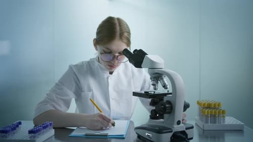 Woman Doing Research with Microscope in Lab