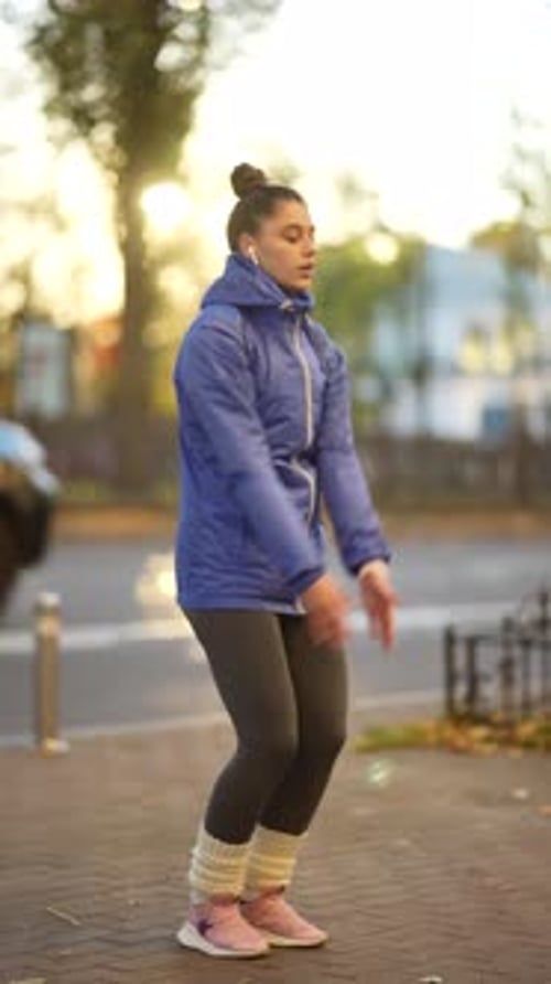 Young Female Athlete in Sportswear Doing Warm Up Exercises on City Street