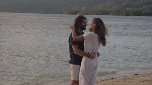 4k video footage of an affectionate young couple embracing each other at the beach