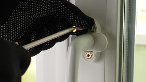 Gloved Hands Repairing Window Handle with Screwdriver