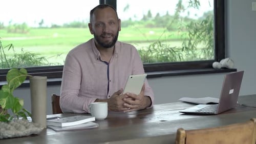 Man with Tablet at Wooden Table Indoors