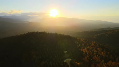 Beautiful Panoramic Mountain Landscape with Hazy Peaks and Foggy Valley at Sunset