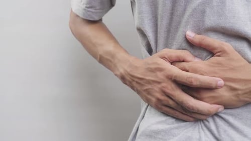 Adult Male Holding Stomach in Painful Expression