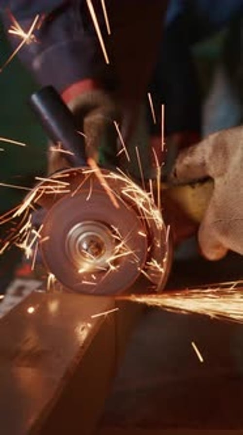 Angle Grinder Sparks Cutting Metal in Dark Workplace
