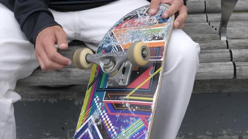 Teenager Prepares To Skateboard, Checks Wheels By Spinning Them, CLOSE UP