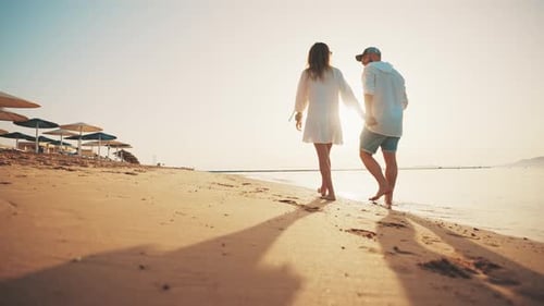 Loving Couple Walking Along Sandy Ocean Beach at Sunny Day Talking Enjoying Time Together Man Woman