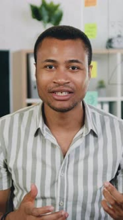 Young Man Talking and Gesturing in Office Setting