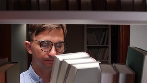 Student Searching for Book on Library Shelf