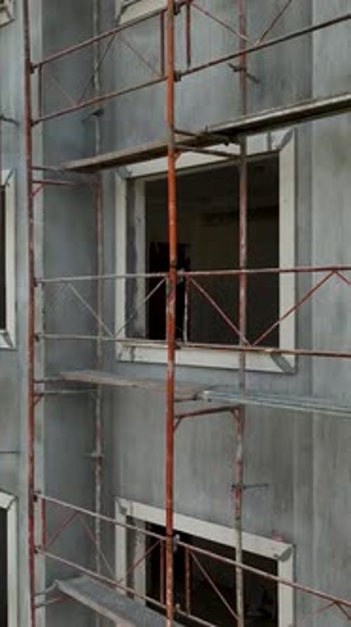 Vídeo vertical sobre cimientos de edificios descargando varillas de metal para andamios