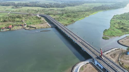 Scenic aerial view of big bridge on big river on rural indonesia. Bridge with green plantation on th
