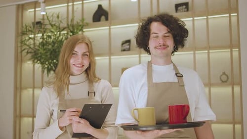 Friendly Young Wait Staff Serving Coffee in Cafe