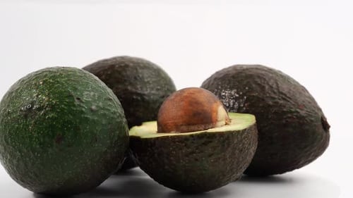 Frische Avocados rotieren auf weißem Hintergrund.
