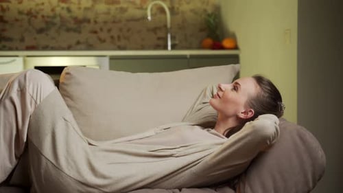 Woman Relaxing on Sofa in Modern Living Room