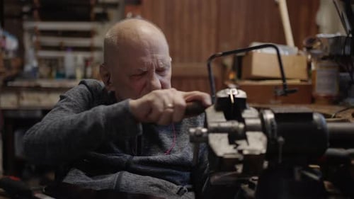 Senior Elderly Master Jeweler in Wheelchair Works in a Workshop