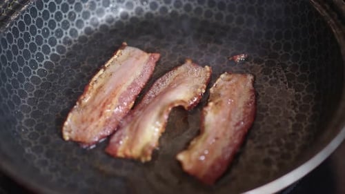 Sizzling Bacon Cooking in Frying Pan