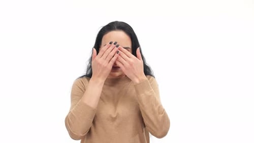 Frau schließt die Augen mit den Händen