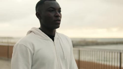 Close-up of young man walking by the sea on the promenade