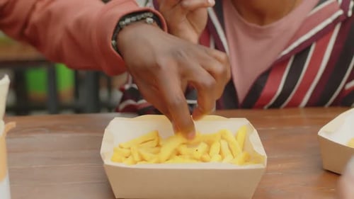 Close Up of People Sharing Fries at a Table