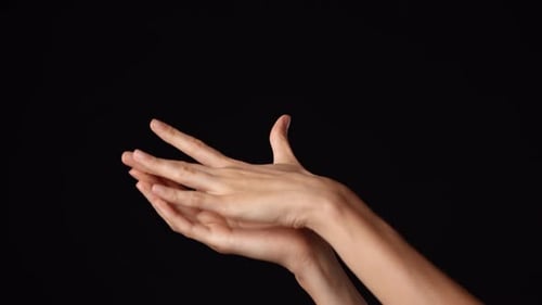 Closeup Studio Shot of Beautiful Caucasian Woman Showing Open Palm and Touching It with Hand