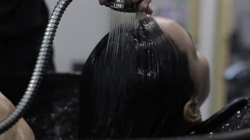 Woman Getting Hair Washed and Combed at Salon