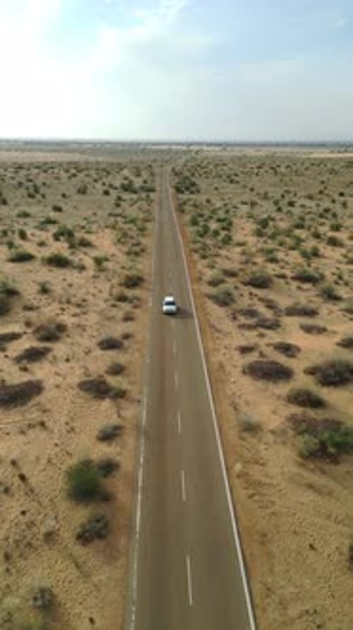 Aerial view of car driving on Longewala road, surrounded by Jaisalmer desert Rajasthan