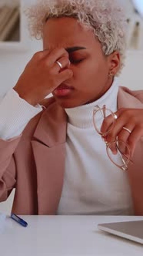 Stressed Professional Woman in Office Rubbing Her Eyes Overwhelmed By Work