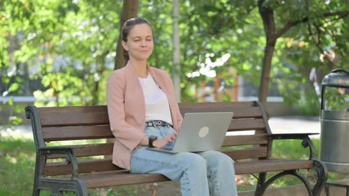Young Woman Works on Laptop in City Park