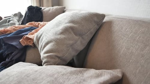 Messy Couch with Folded Laundry Indoors
