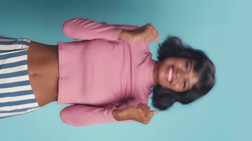 Young African American Woman Laughs and Dances Incendiary Dance Posing in Studio