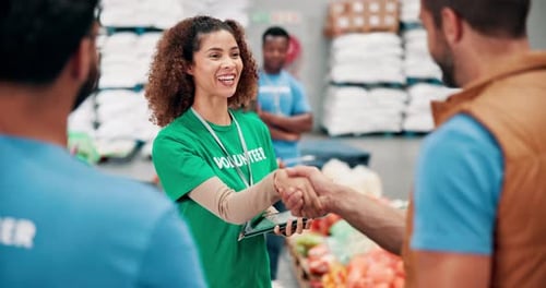 Volunteers Shake Hands at Food Bank Warehouse