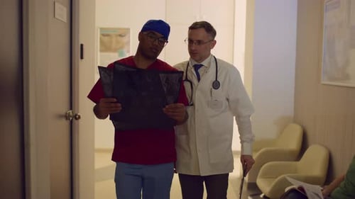Doctors Discussing X-rays in Hospital Corridor