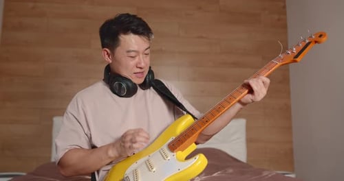 Young Adult Plays Electric Guitar at Home