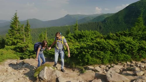 A Guy Helps His Girlfriend When Climbing a Mountain Active Lifestyle