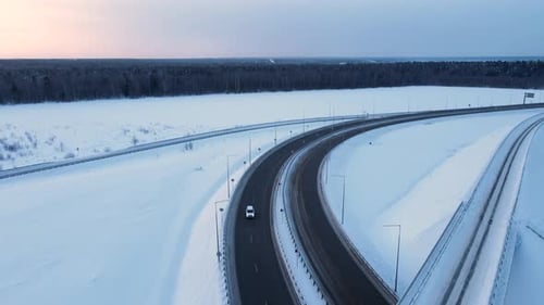 Paysage enneigé avec autoroute et pont au coucher du soleil, vue aérienne