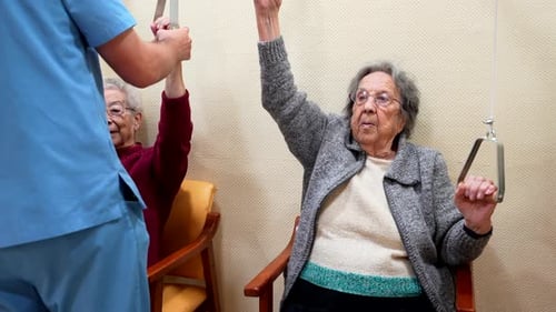Elderly Women Exercising Arms with Nurse Assistance in Nursing Home