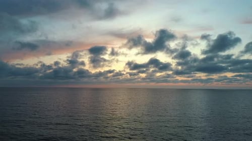 Drone volant à reculons Au-dessus de la mer après le coucher du soleil. Superbe prise de vue par Drone aérien au coucher du soleil sur la mer. Lever du soleil