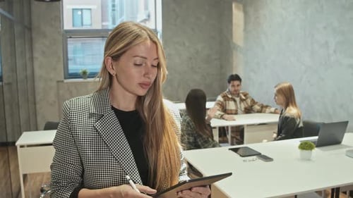 Woman Using Tablet in Modern Office Setting