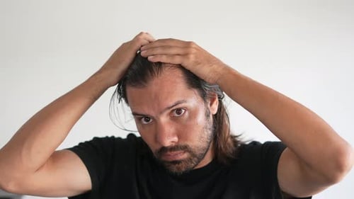 Man Running Hands Through Hair in Close Up