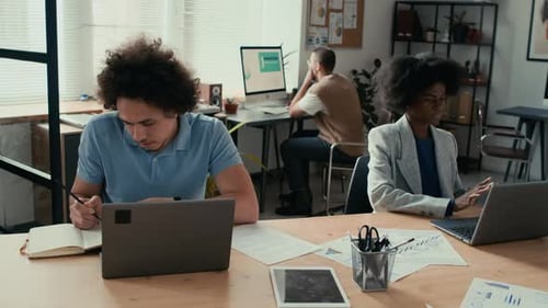 Multi-Ethnic Colleagues Working Hard on Business Project in Open Space Office