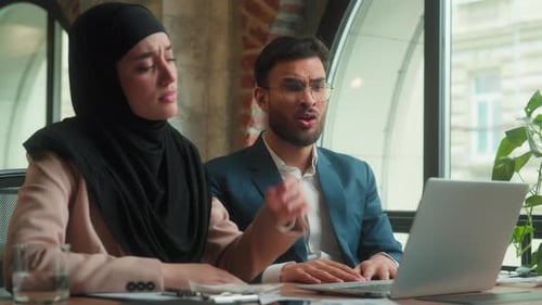 Stressed Colleagues Arguing at Desk in Office