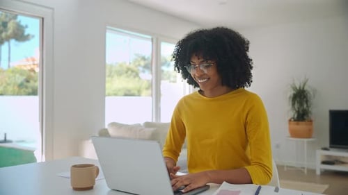 Woman Typing on Laptop at Home Smiling