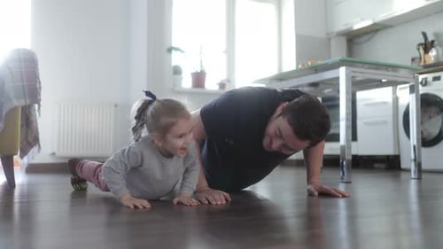 Father and Daughter Exercising Together Indoors