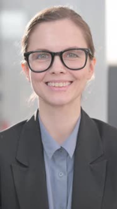Portrait of Smiling Young Businesswoman in Office, vertical video