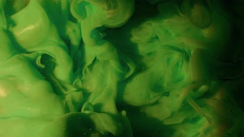 Green Liquid Swirling in Gold Fluid
