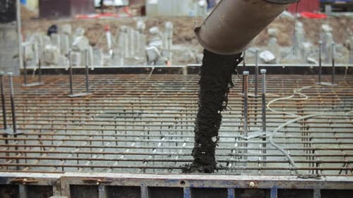 Concrete Being Poured Onto Steel Reinforcement Grid