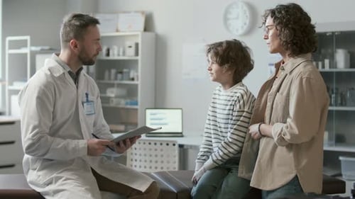 Doctor Discussing Health Concerns with Mother and Kid in Pediatric Clinic